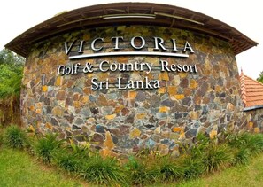 Un mur de pierre sur lequel est inscrit le texte : « VICTORIA Golf & Country Resort, Sri Lanka ».