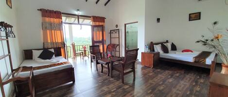 A room with a bed, a sofa, a dining table with chairs, and a balcony with curtains.