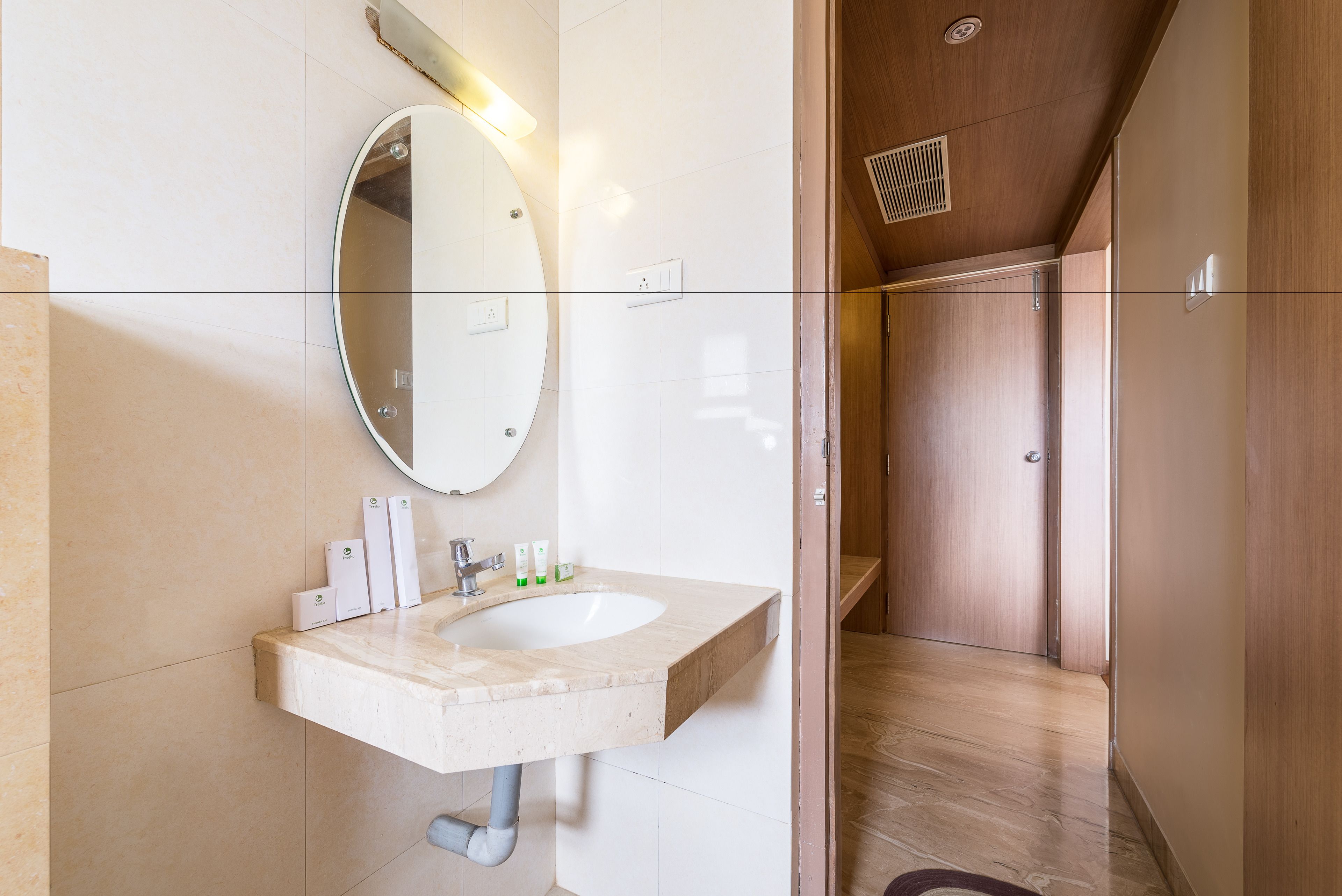 Un baño moderno con lavabo de mármol, un espejo grande y cabina de ducha de madera.