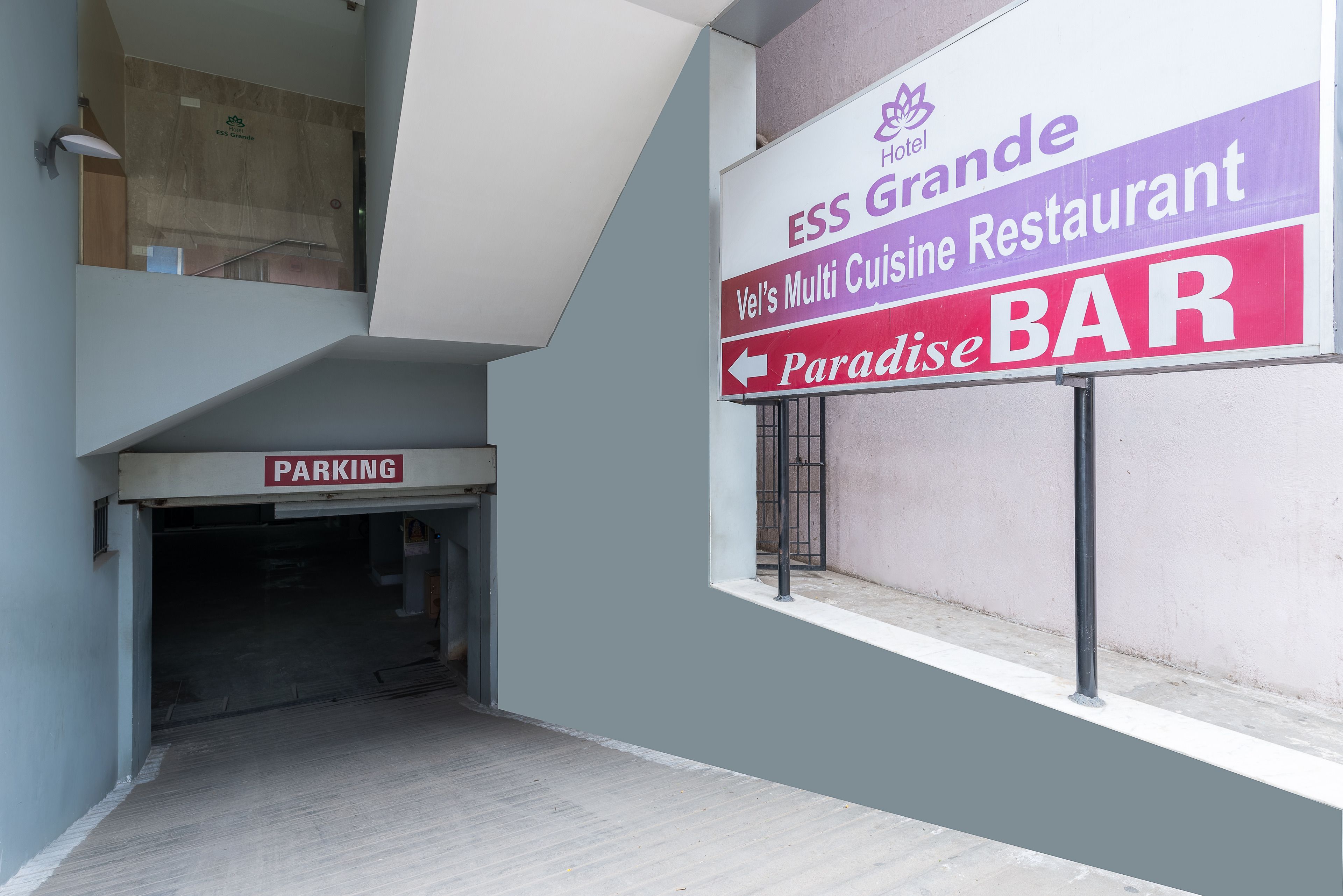 Interior de hotel con un cartel anunciando ESS Grande, el restaurante de cocina variada de Vel's, y el bar Paradise.