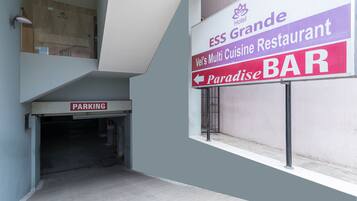 Interior de hotel con un cartel anunciando ESS Grande, el restaurante de cocina variada de Vel's, y el bar Paradise.