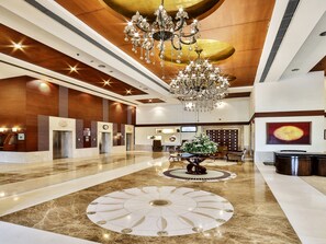 A spacious lobby with a grand chandelier, elevators, and a reception desk. - Regenta Central Klassik (Ludhiana)