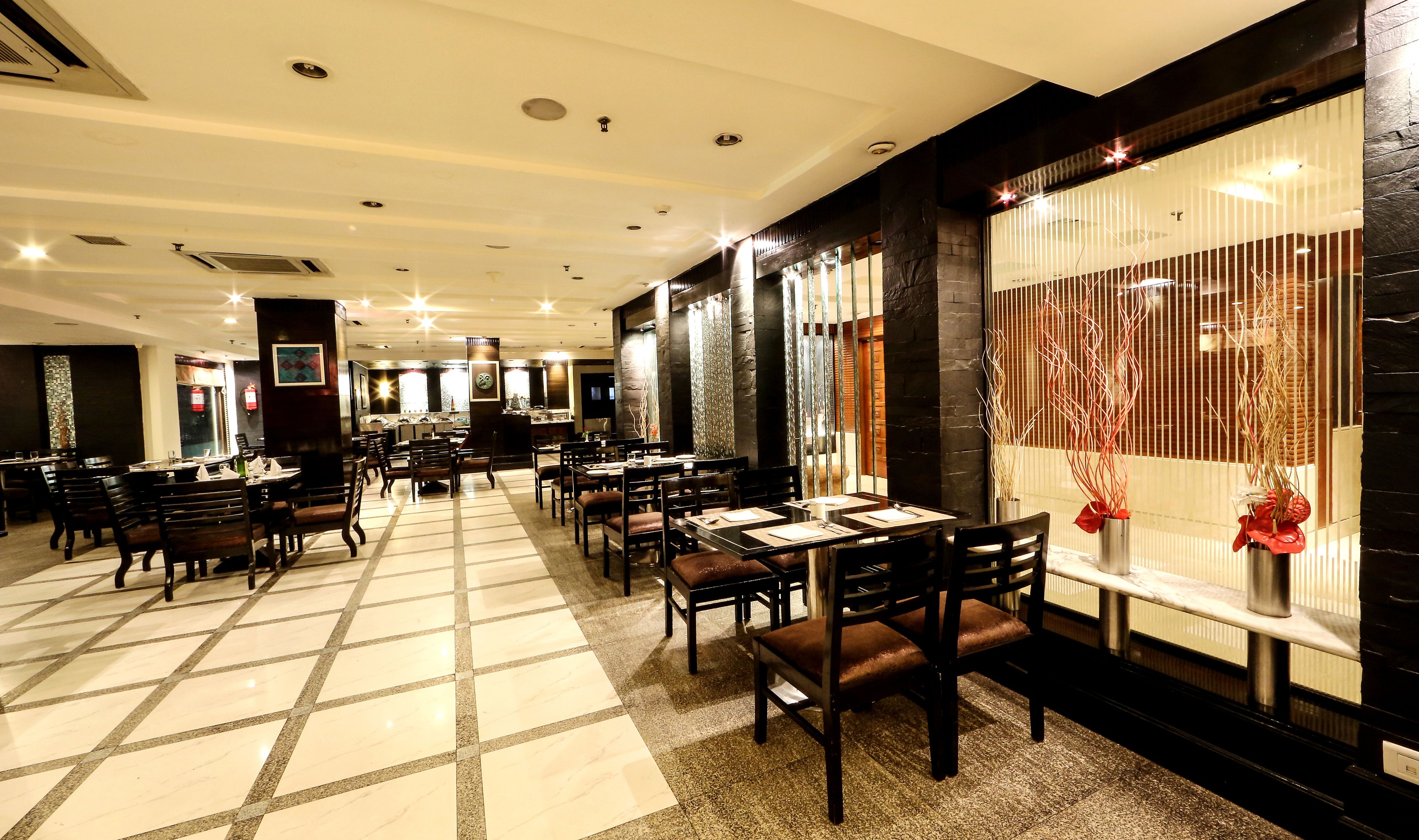 A spacious restaurant with high ceilings, multiple dining tables, and chairs.
