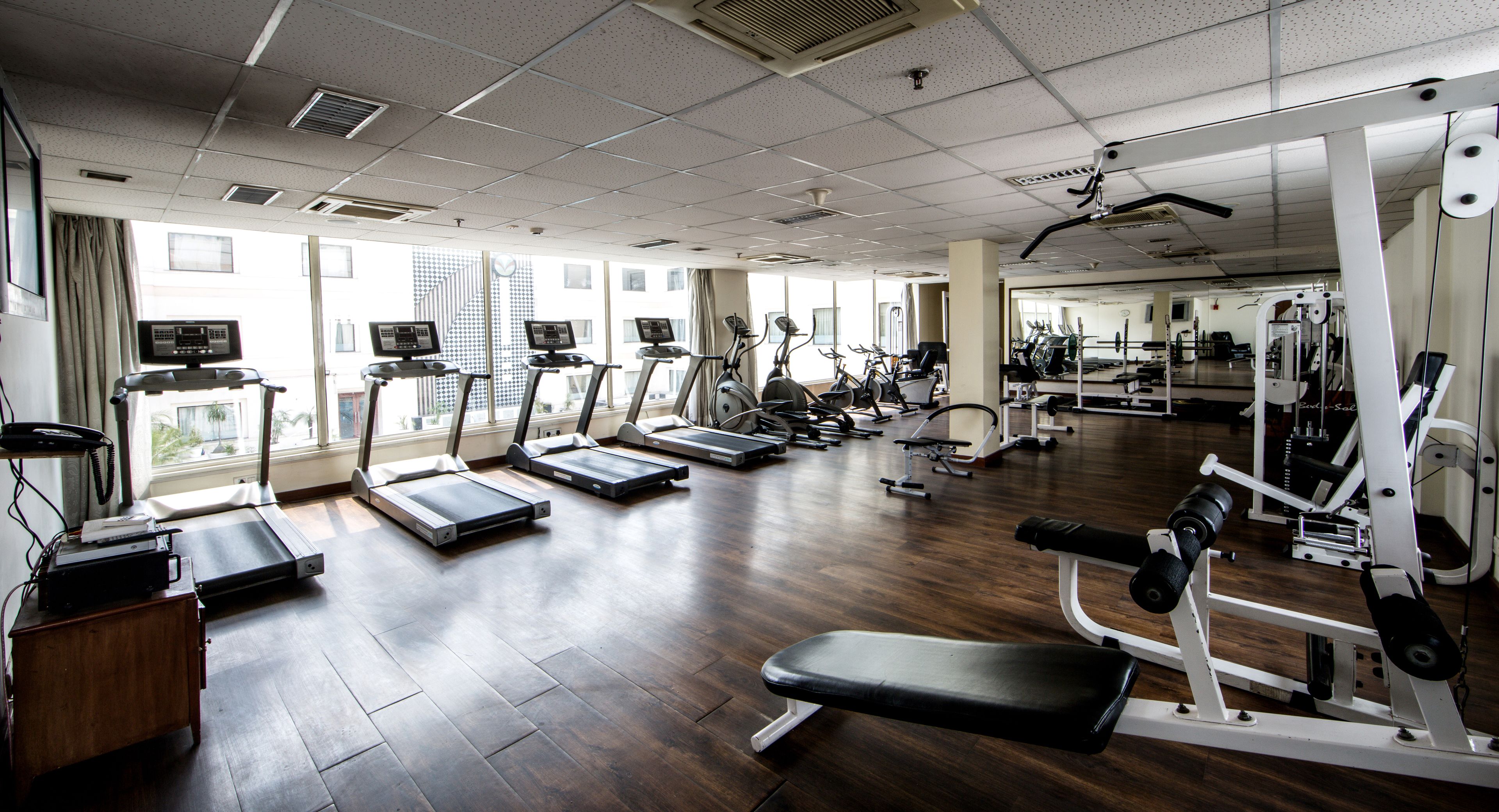 A gym with treadmills, elliptical machines, and weight equipment.