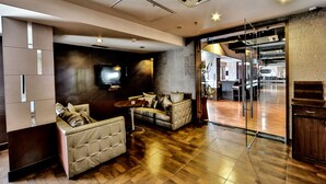 A modern living room with a flat-screen TV, two sofas, a coffee table, and a wooden floor. - Regenta Central Klassik (Ludhiana)