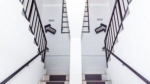 Una escalera con barandillas negras y escalones de piedra.