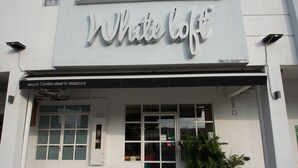 Un edificio con un letrero que dice "White loft" y un cartel debajo que indica "Donde los ciclistas se encuentran en Malaca".