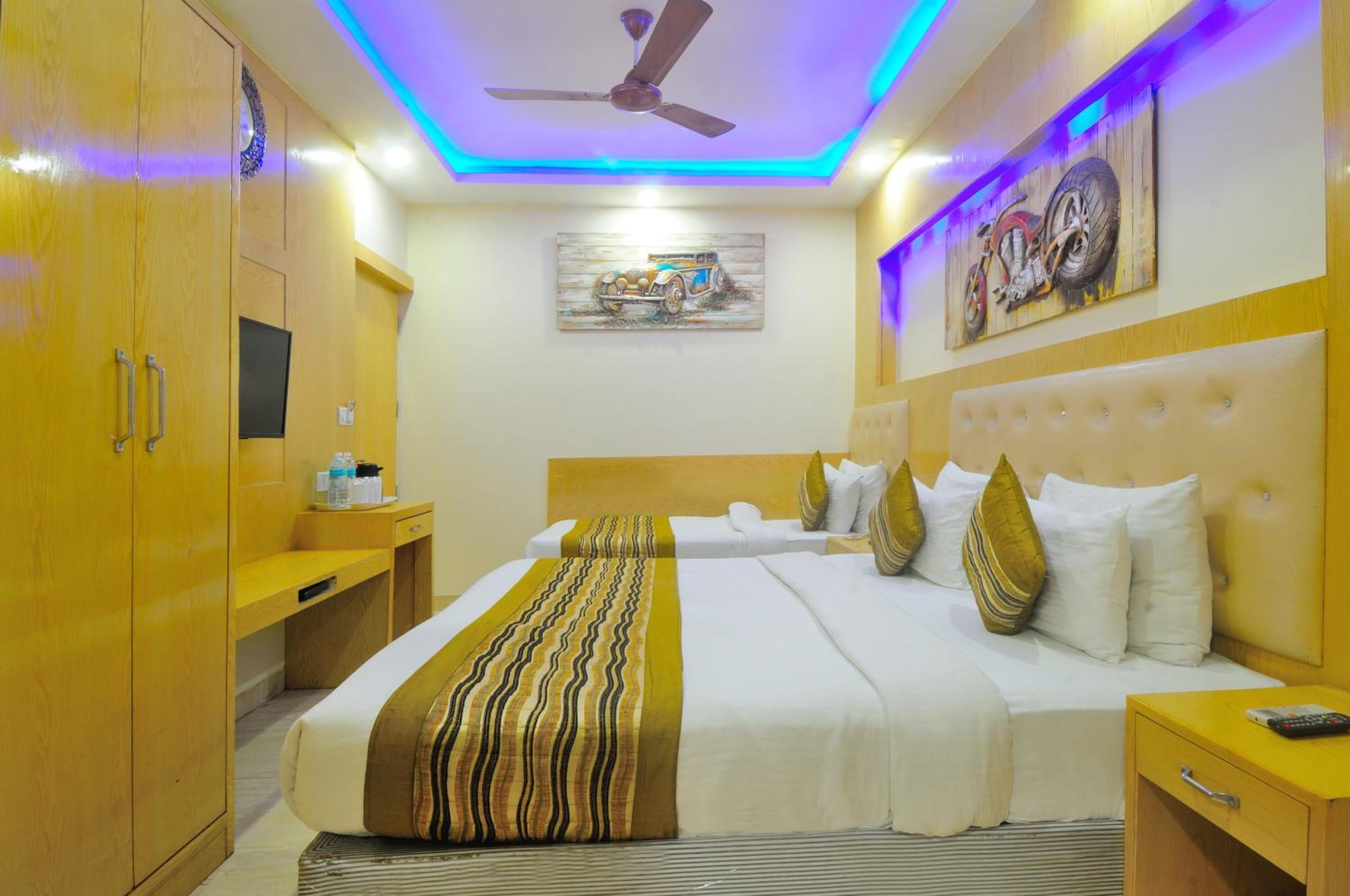 Una habitación de hotel con cama, mesitas de noche, armario y ventilador de techo.