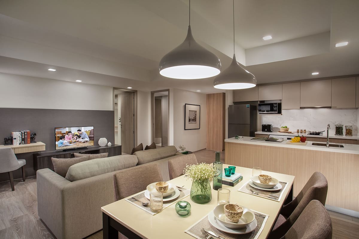 Una sala moderna con sofá, mesa de comedor y área de cocina.