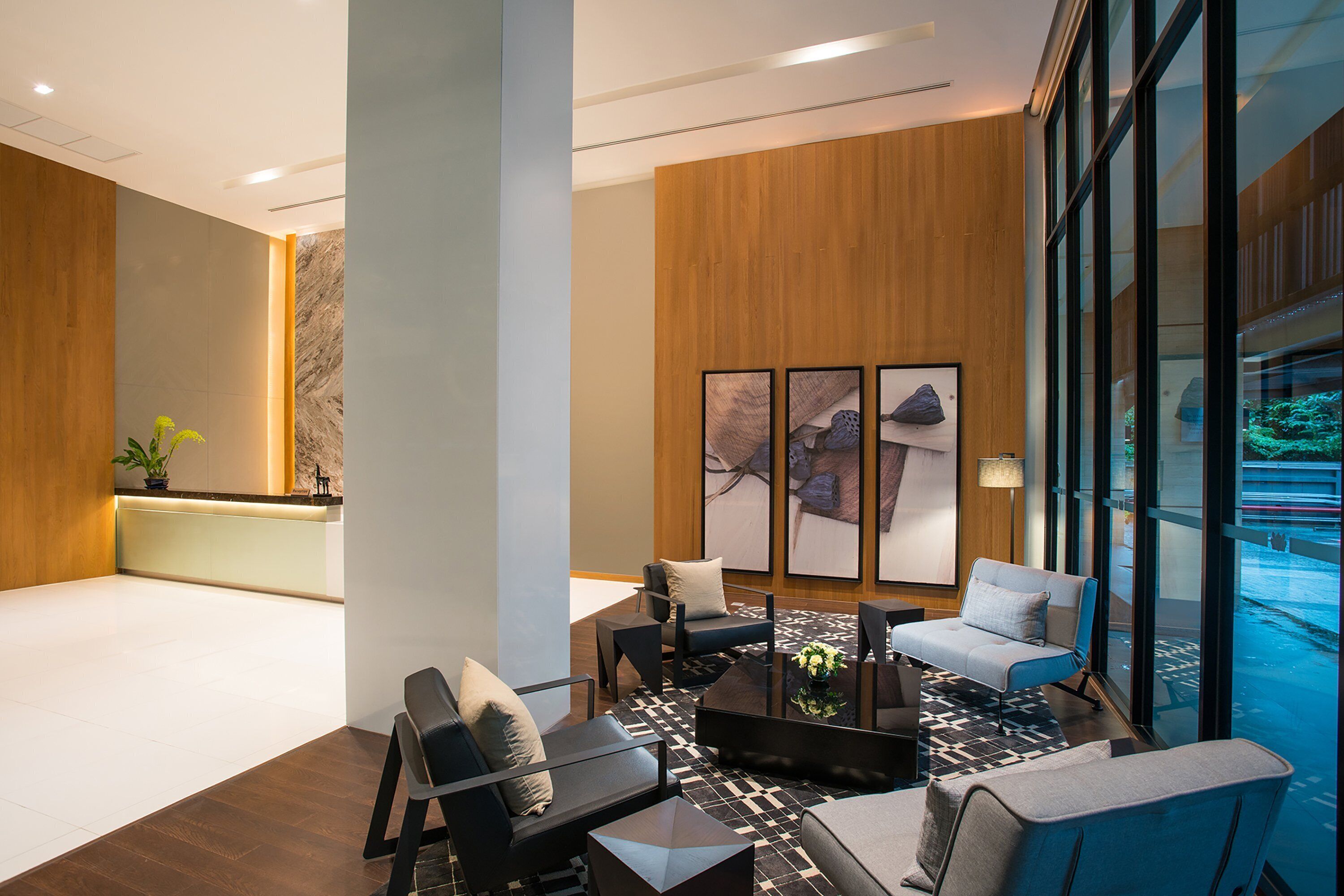 Eine moderne Lobby mit Empfangstresen, Sitzgelegenheiten und großen Fenstern.