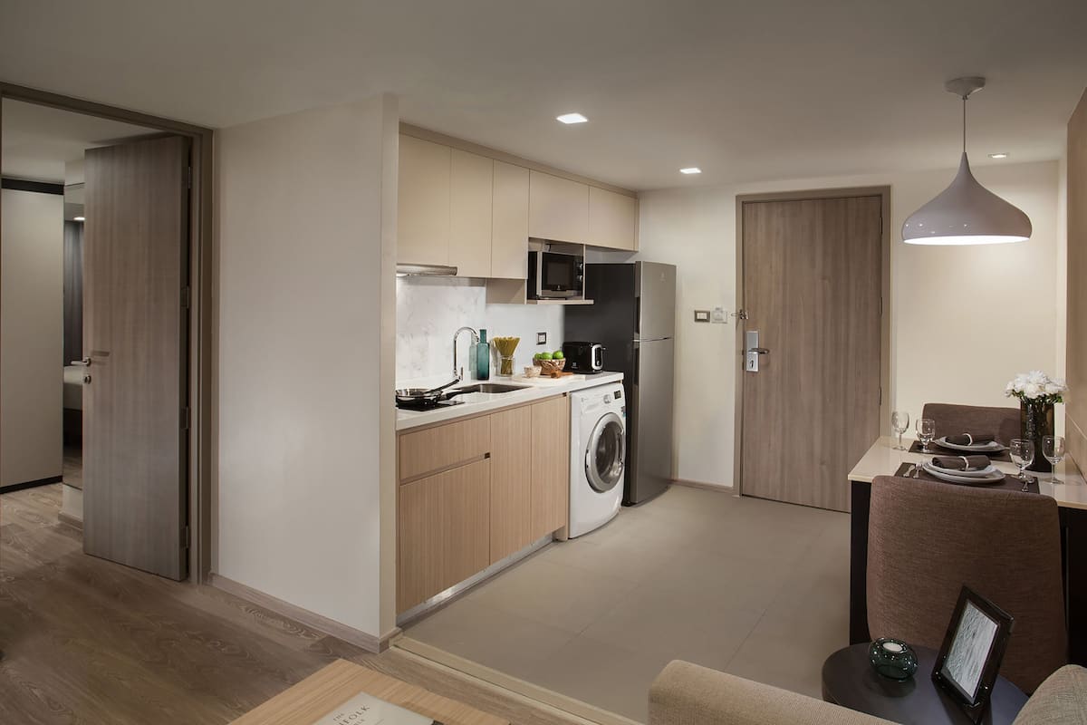 Una cocina moderna con lavadora, microondas y refrigerador.