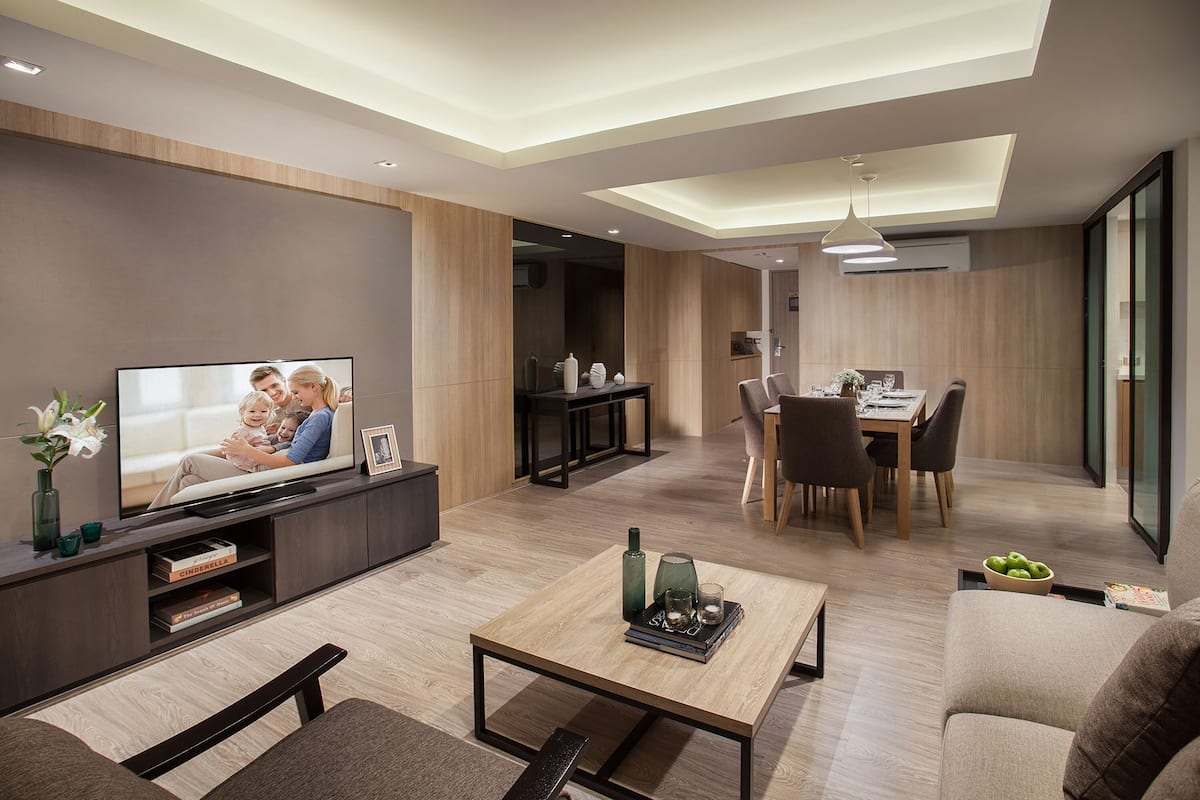 Una sala de estar moderna con un televisor de pantalla plana, una mesa de centro, un sofá y un comedor con sillas y una mesa.