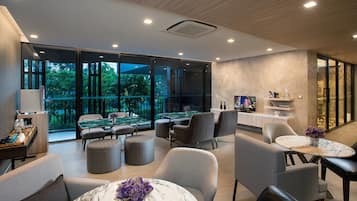A modern lounge area with a pool table, comfortable seating, and a view of the outdoors.