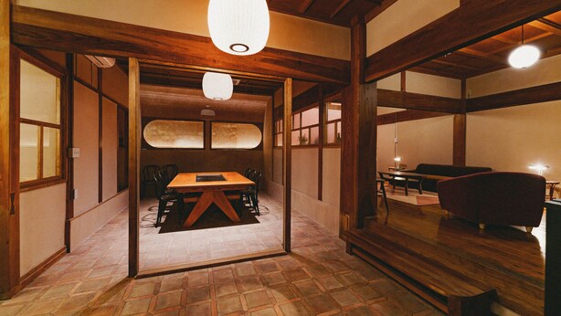 A traditional Japanese-style room with tatami flooring, a low wooden table, and a red sofa. - Kominka Yado LOOF Sakanoie (Fuefuki)