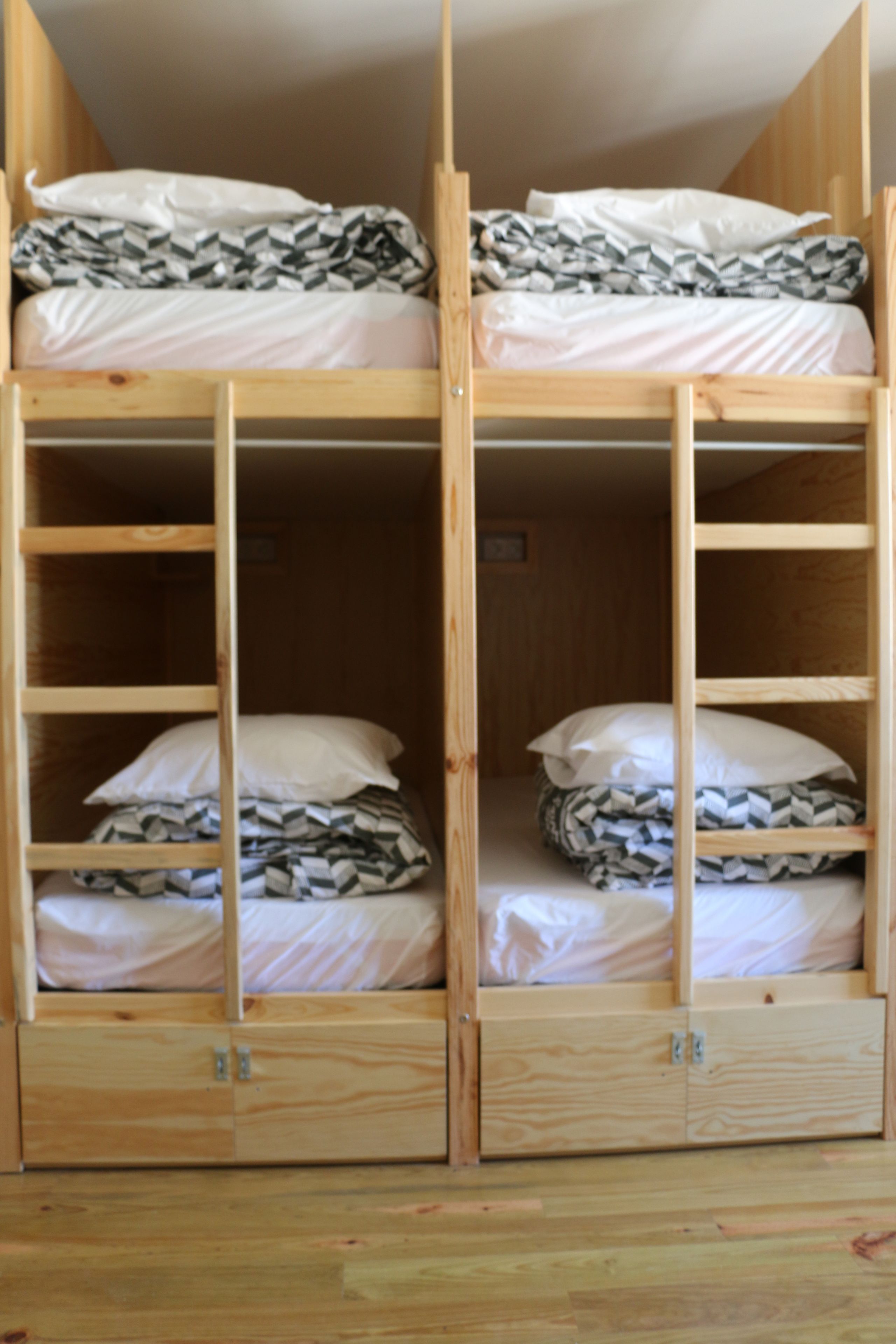 A bunk bed with two levels, each with a pillow and a blanket.
