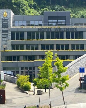 A modern hotel building with a sign reading "HOTEL WELLNESS." - Hotel Wellness Eau de Roche (Durbuy)