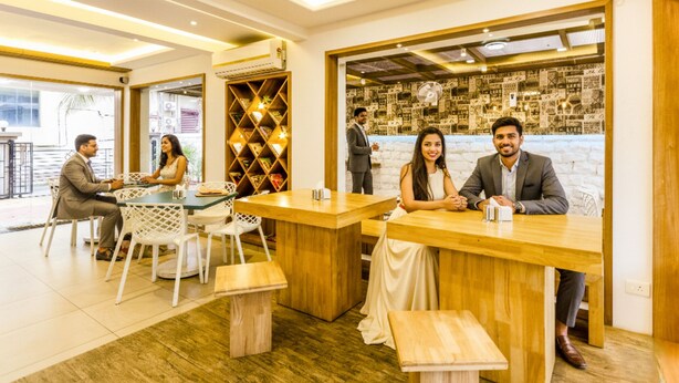 A modern interior with wooden furniture, a reception desk, and a wall with a grid pattern. - FabHotel Imperio (Pune)