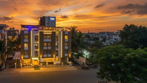 A hotel with a modern design, featuring multiple floors and a prominent sign on the rooftop. - FabHotel Imperio (Pune)