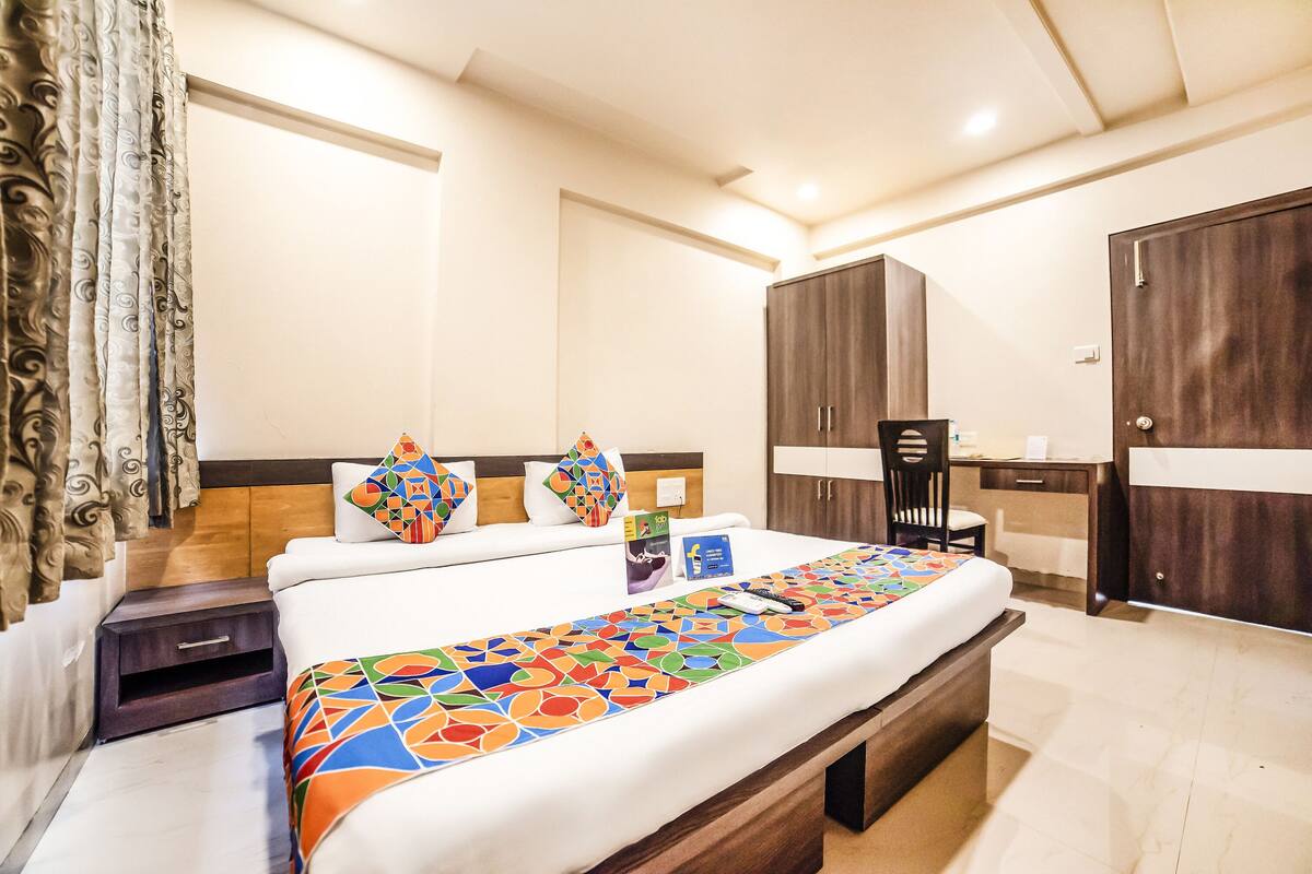 A hotel room with a bed, a desk, and a wardrobe.