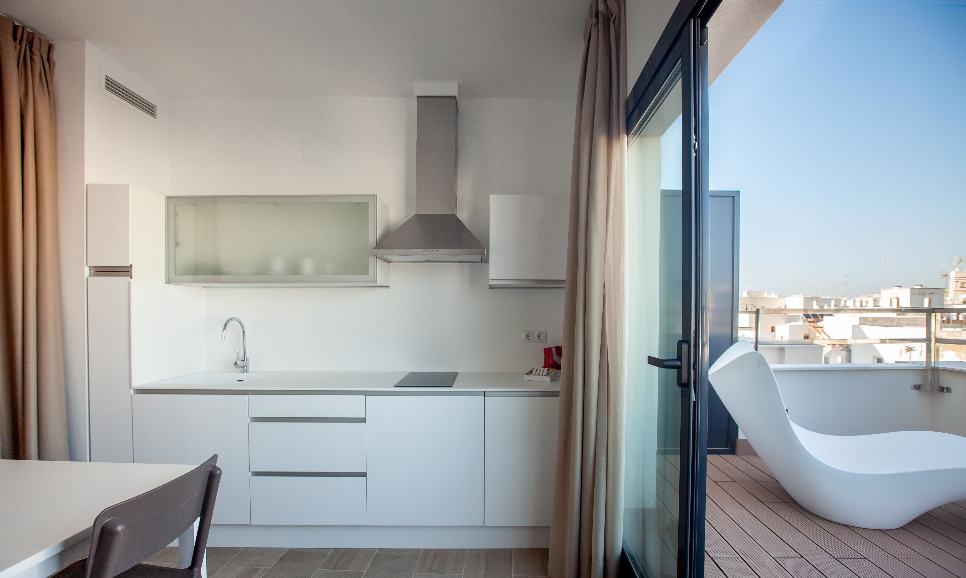 Una cocina moderna con estufa integrada, un lavamanos y ventana con vistas a la ciudad.