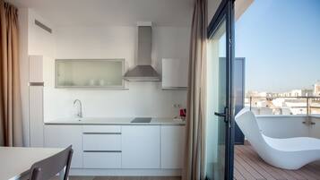 Una cocina moderna con estufa integrada, un lavamanos y ventana con vistas a la ciudad.