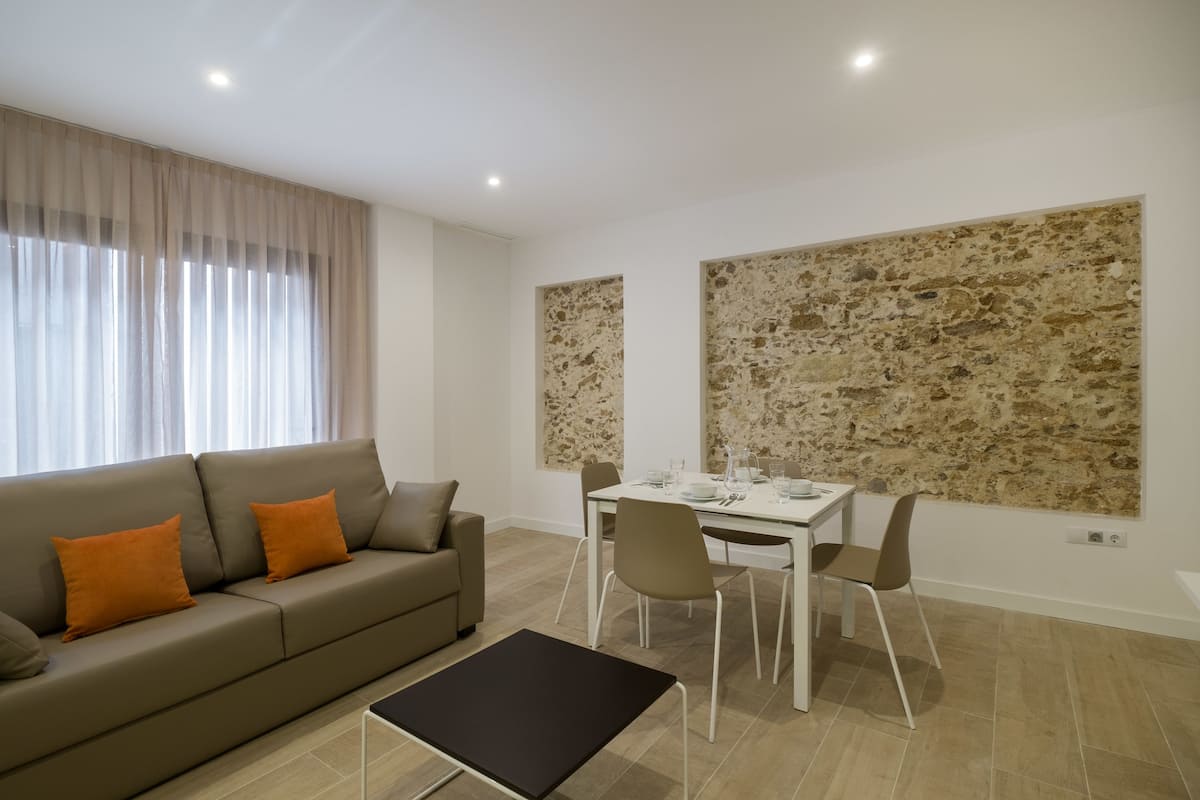 Ein modernes Wohnzimmer mit einer Couch, einem Esstisch und Stühlen.