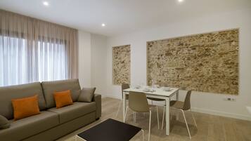 Un salon moderne avec un canapé, une table à manger et des chaises.