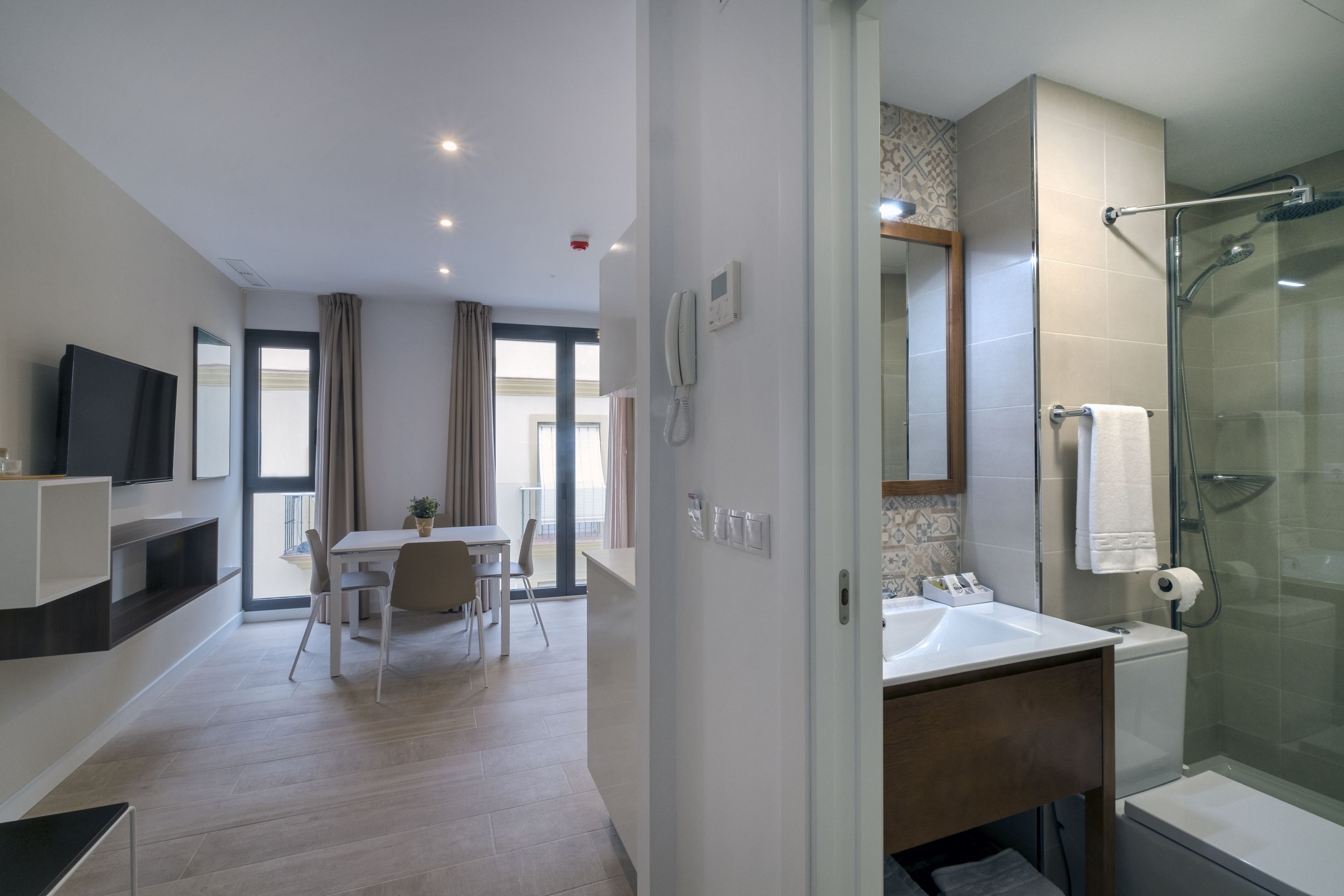 Een moderne hotelkamer met een groot bed, een aparte badkamer, een zithoek en een televisie.