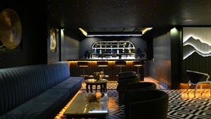 Eine moderne Bar mit Sternenhimmel, einer Couch und einem gemusterten Boden.