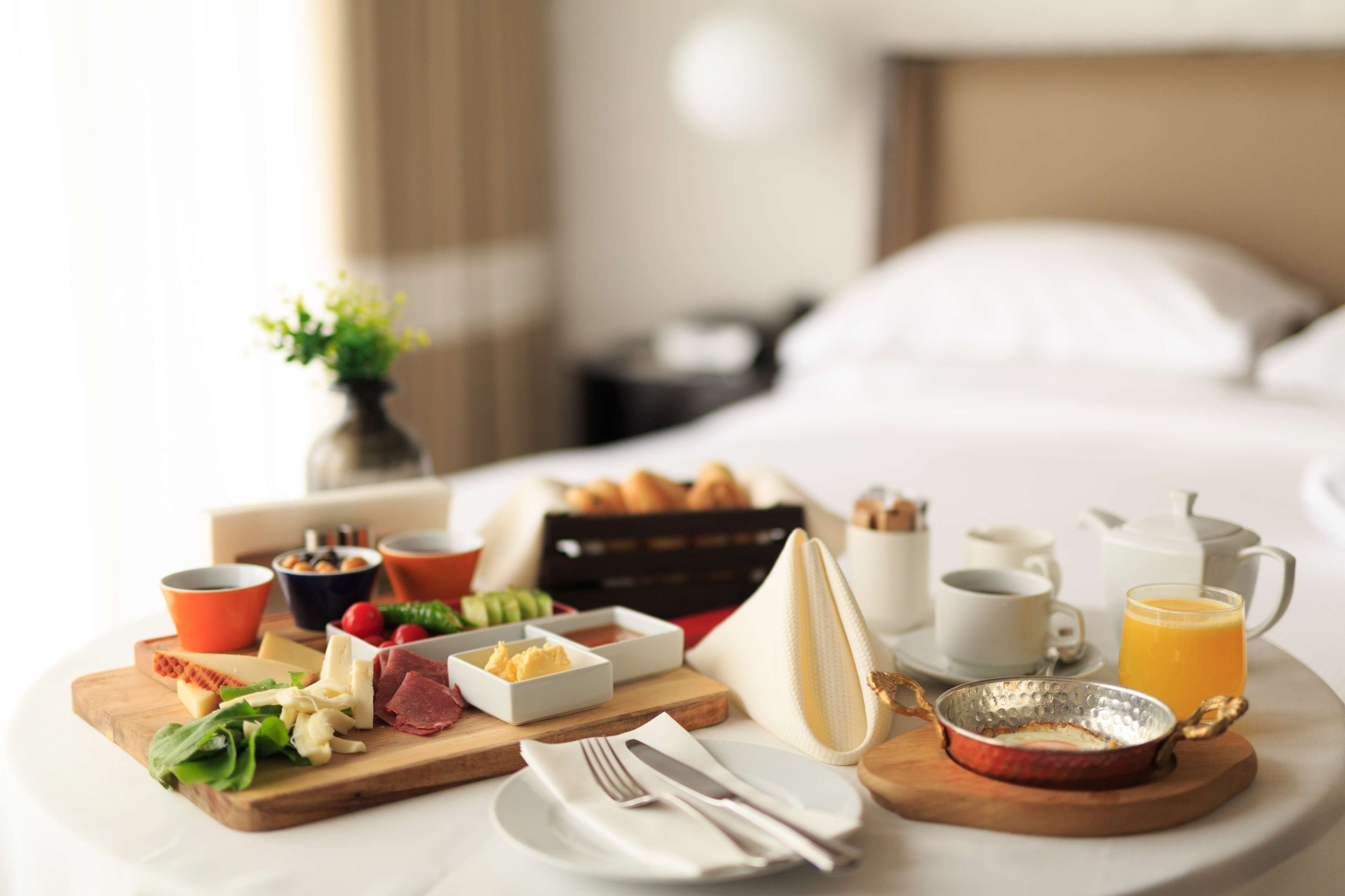 A breakfast tray with various foods and drinks on a table in a hotel room.