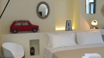 Une chambre à coucher avec un lit, une chaise, une lampe, un miroir et une voiture jouet.