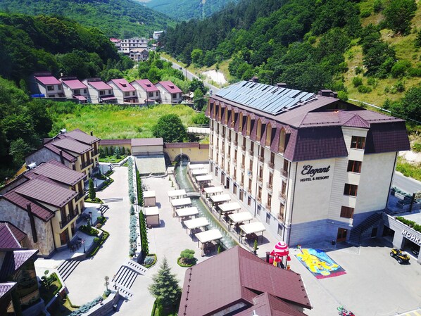 A hotel with a central courtyard, multiple balconies, and a river view.