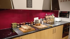 A kitchen counter with jars of jam, bread, and muffins. - The Old Mill Holiday Hostel (Westport)