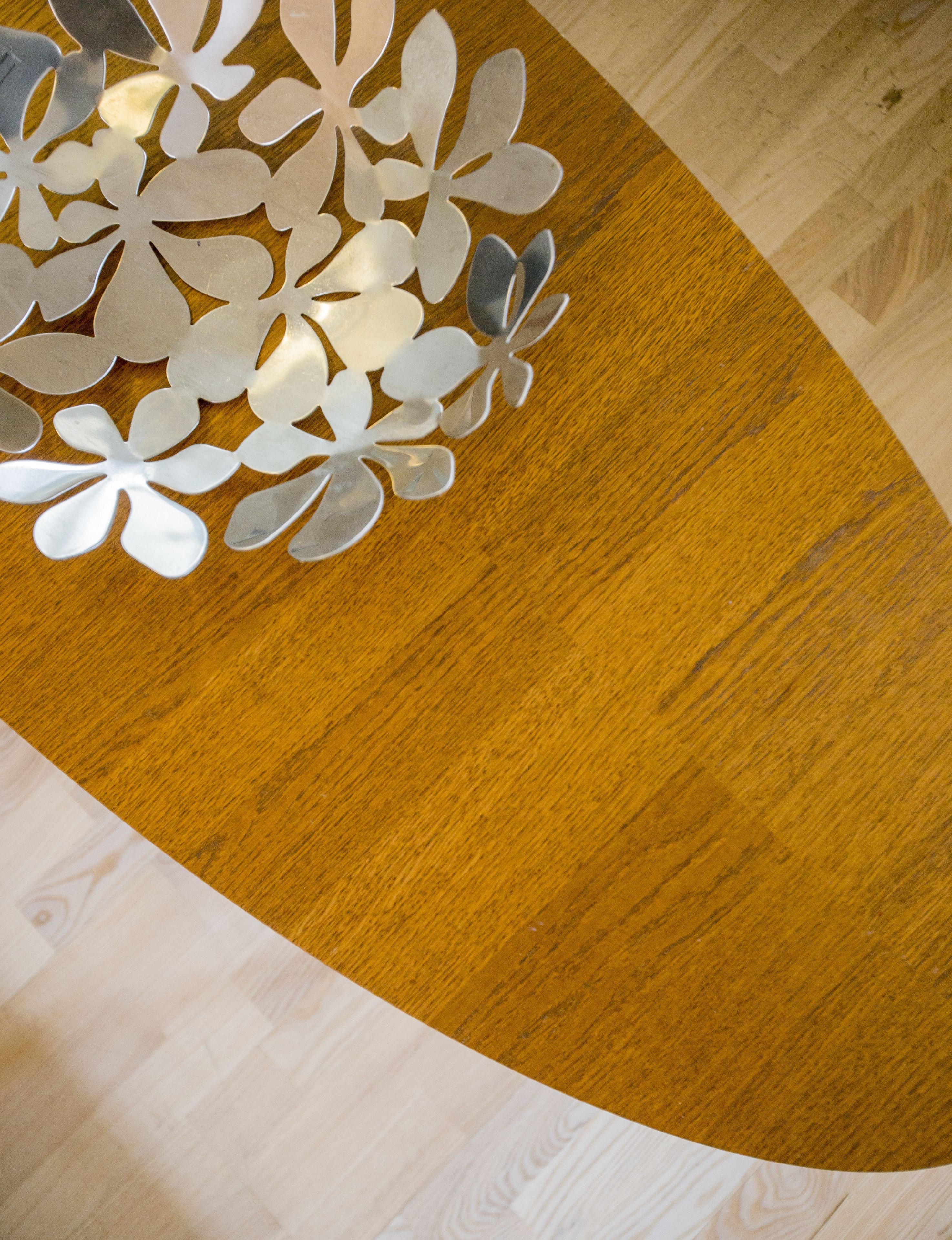 A wooden table with a white decorative cut-out design.