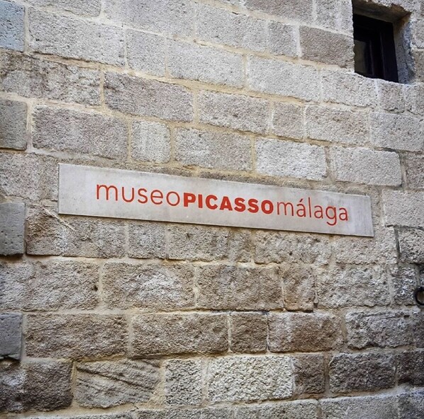 A stone wall with a sign that reads "museopicassomalaga".