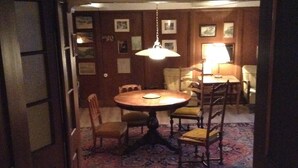 A dining area with a round table and chairs, a hanging light fixture, and a patterned rug. - 200 Year Old Swiss House (Erlenbach im Simmental)