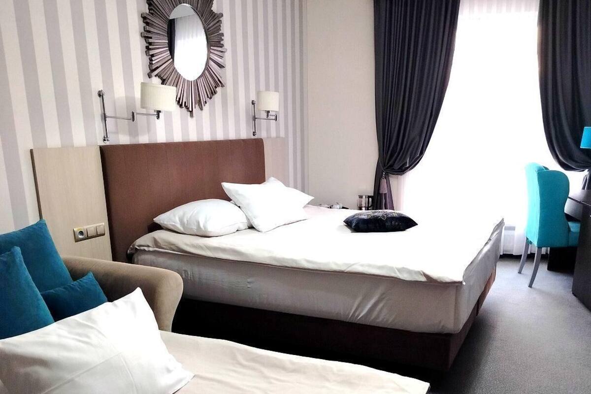 Een hotelkamer met twee bedden, een grote spiegel, een bureau en een stoel.