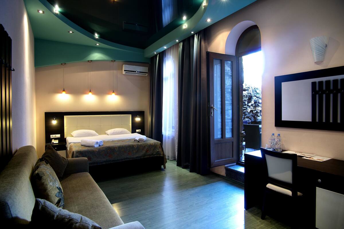 Ein Hotelzimmer mit Bett, Schreibtisch, Sessel und einer Couch.