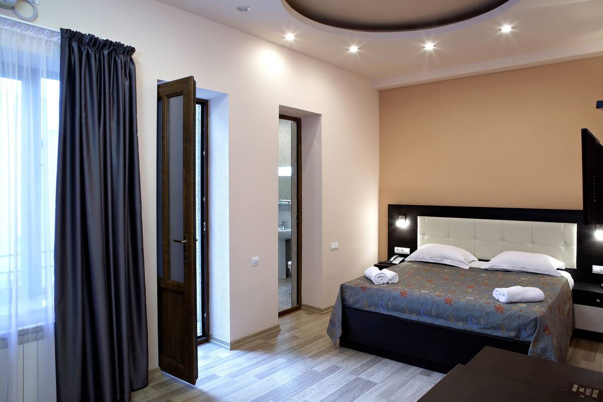 Ein Hotelzimmer mit Bett, Schreibtisch und Spiegel.