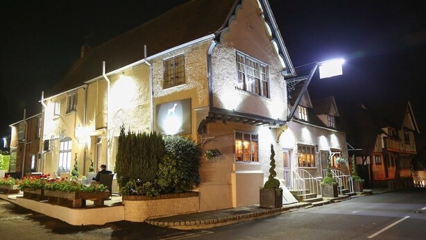 A traditional building with a sloped roof, multiple windows, and a well-lit entrance. - The Dog at Wingham (Canterbury)