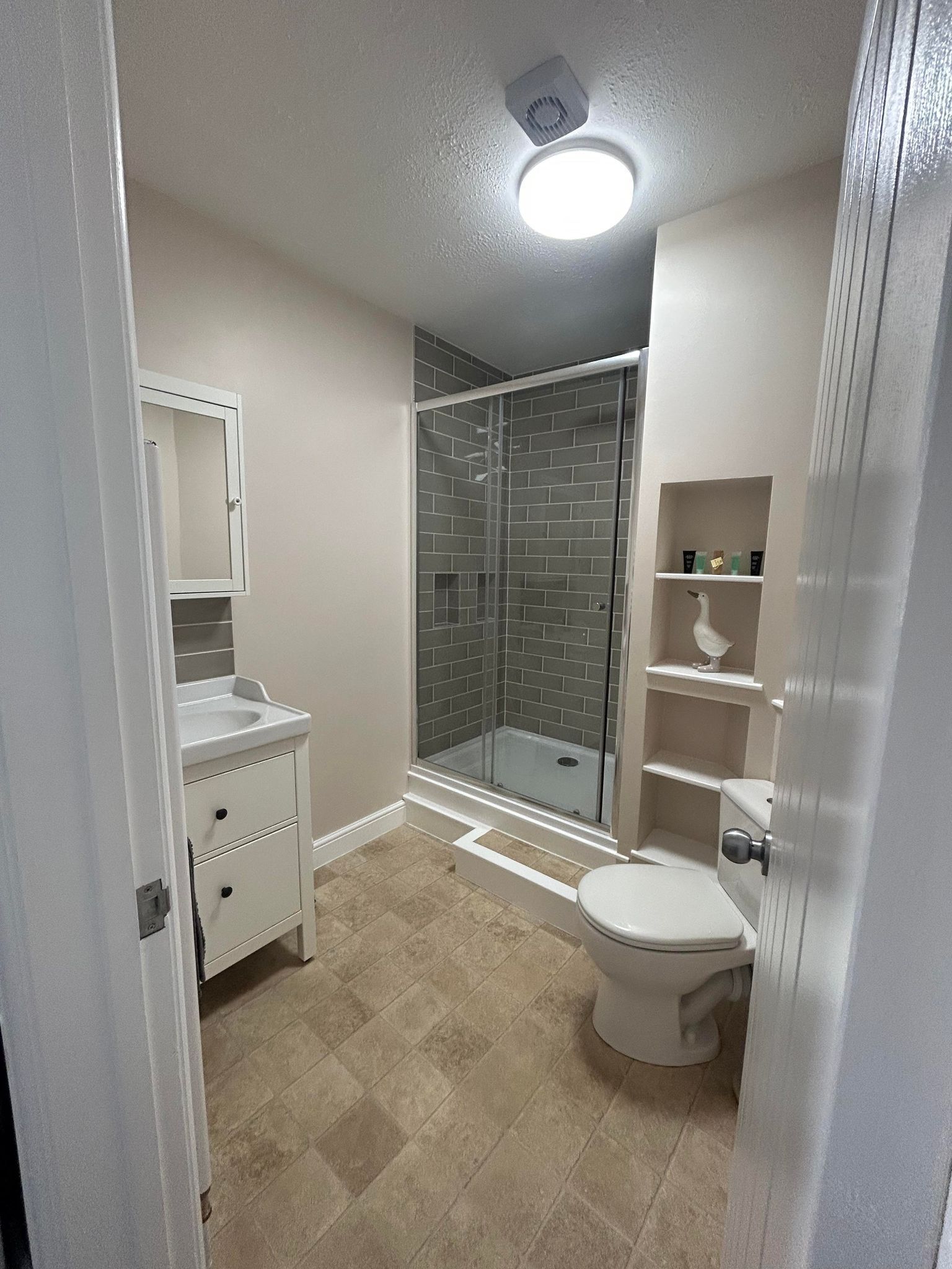 A bathroom with a shower, toilet, and vanity.
