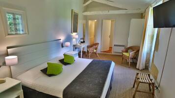 A bedroom with a bed, bedside table, lamp, and a chair.