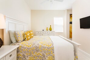 A bedroom with a bed, bedside tables, a dresser, a window with blinds, and a TV on the wall. - Villa The Nantucket at Patriots Landing 3 Bedroom Reunion (Kissimmee)