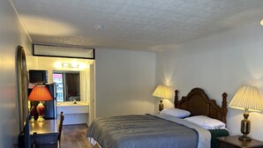 A bedroom with a bed, bedside lamps, a mirror, a dresser, and a window. - Lemon Inn (Spruce Pine)
