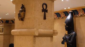 A column with an Egyptian-themed design, including a carved face and an ankh symbol.