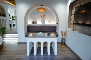 A modern interior with a white arched seating area, a small table with a tissue box, and a mounted TV.