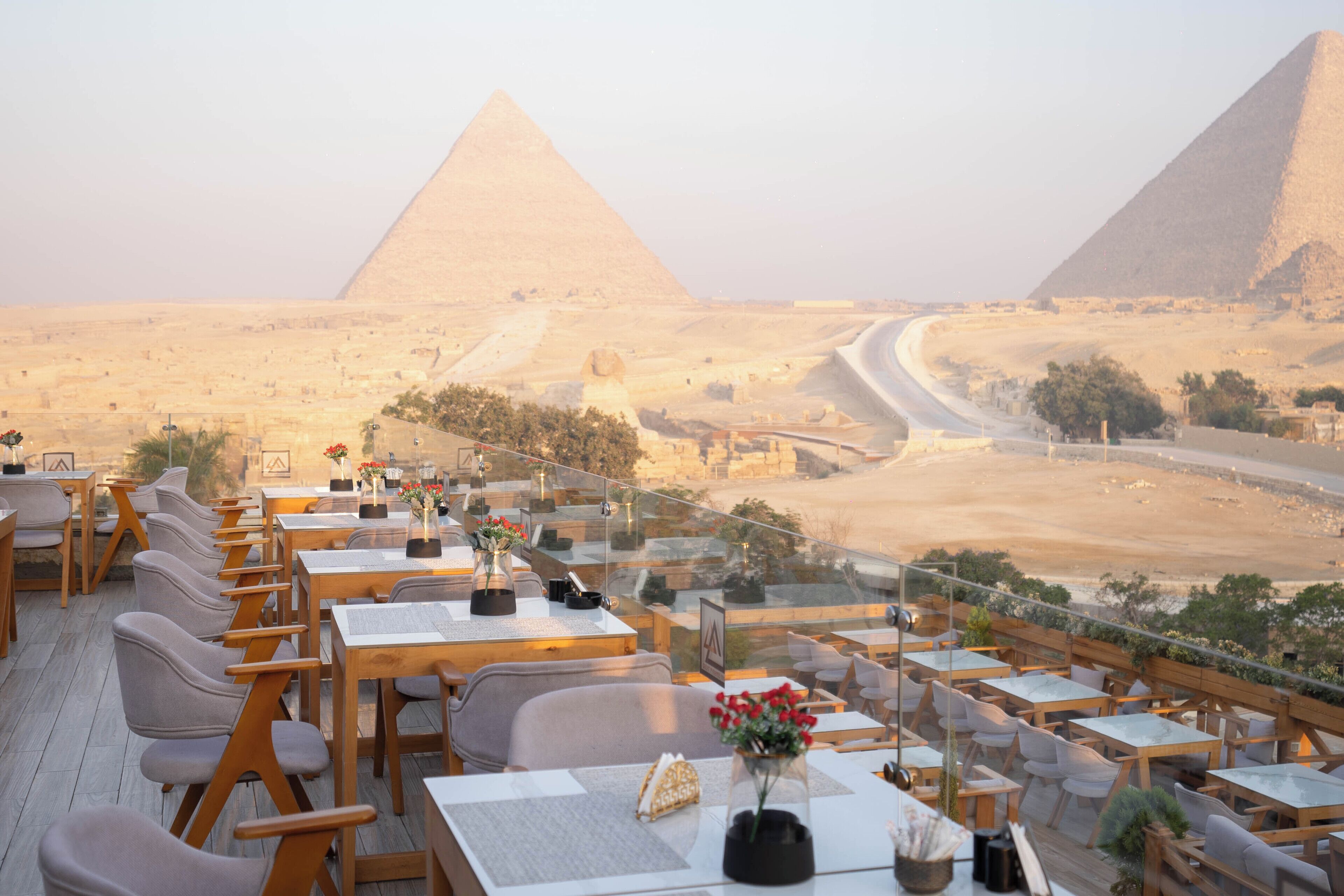 A restaurant with outdoor seating overlooking the pyramids.