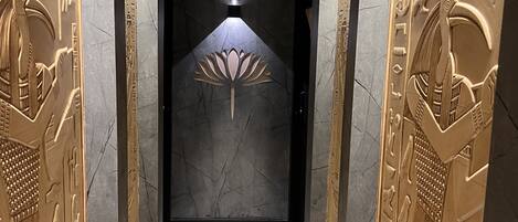 Een gang met Egyptische wanddecoraties en een lotusbloem ontwerp op de muur.