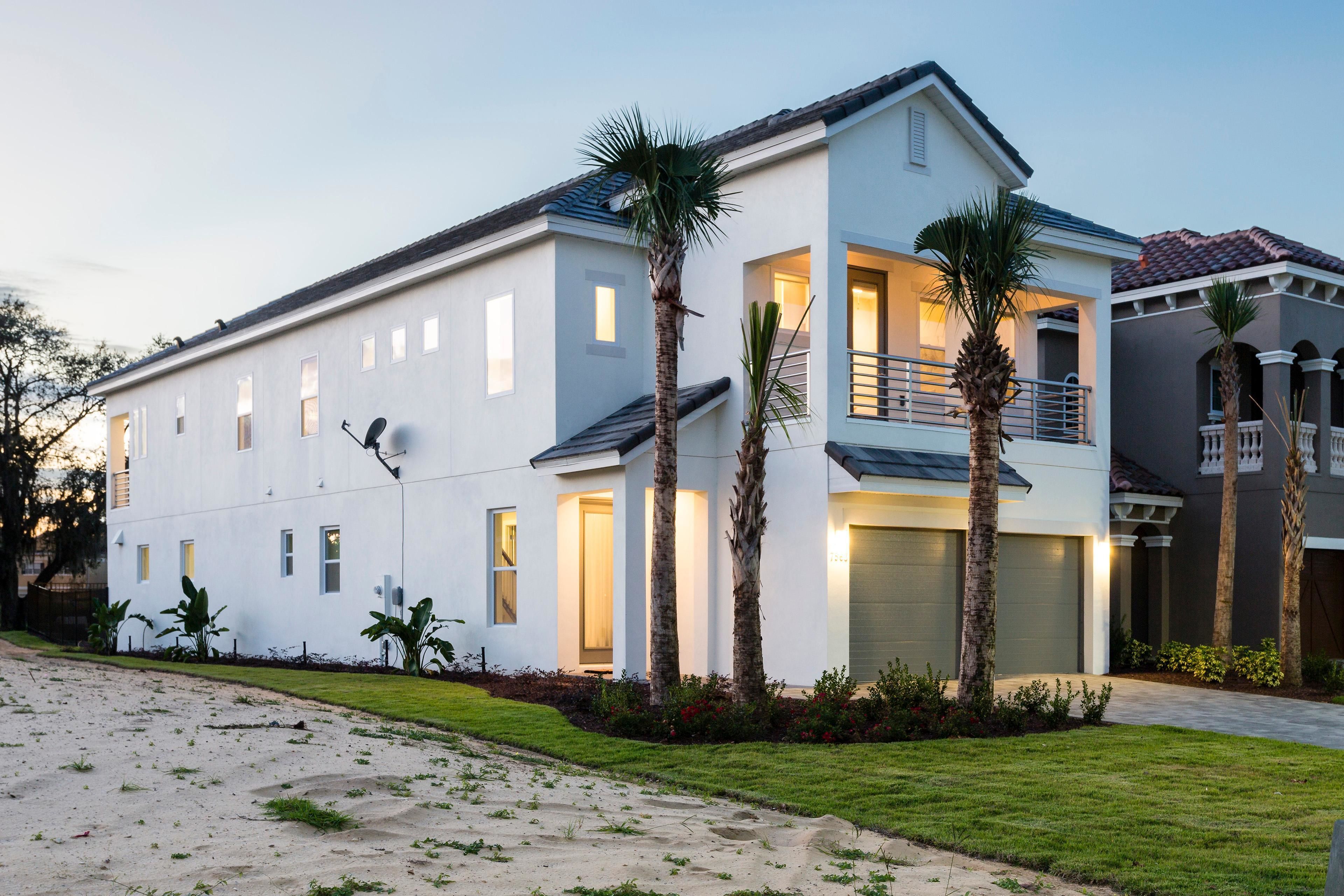 A two-story house with a balcony, a garage, and a well-maintained lawn.