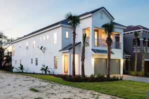 Una casa de dos pisos con balcón, garaje y un césped bien cuidado.